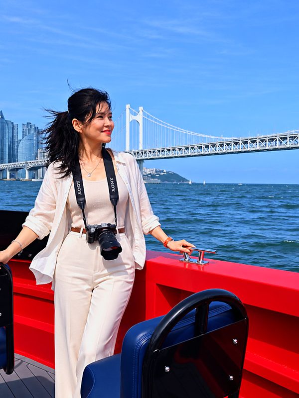 Guest taking photos on the boat in front of Gwangan Bridge