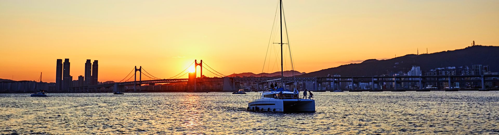 Yacht in front of Gwangan Bridge at sunset