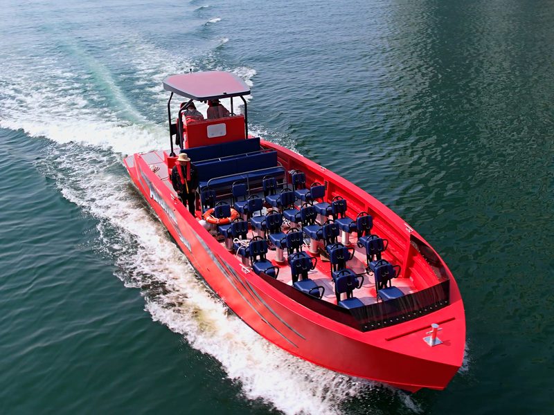Red adventure boat slicing through the waves