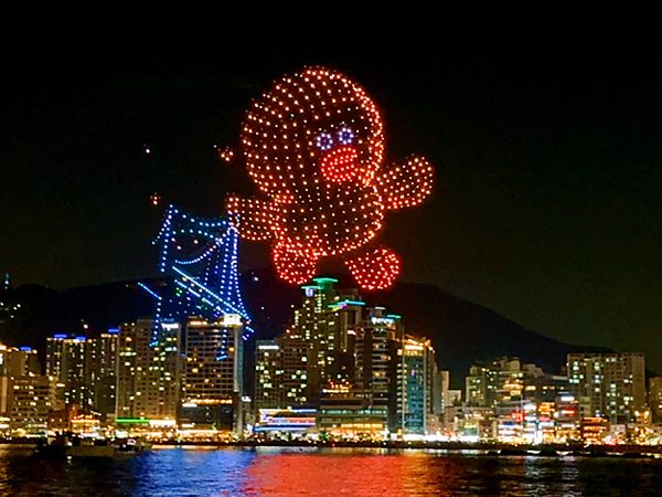 Character-shaped drone show rising over Gwangan Bridge