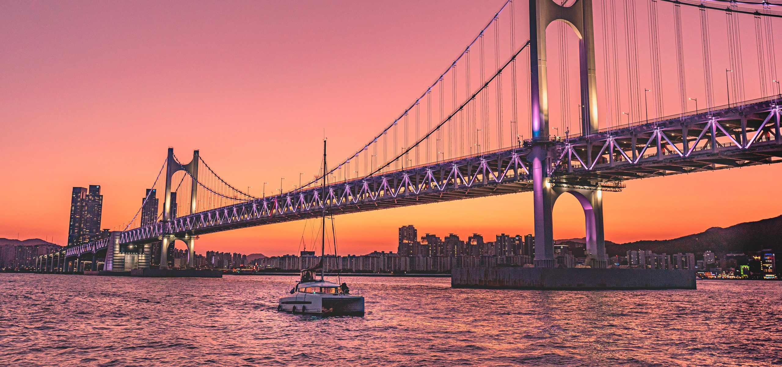 Yacht in front of Gwangan Bridge at sunset