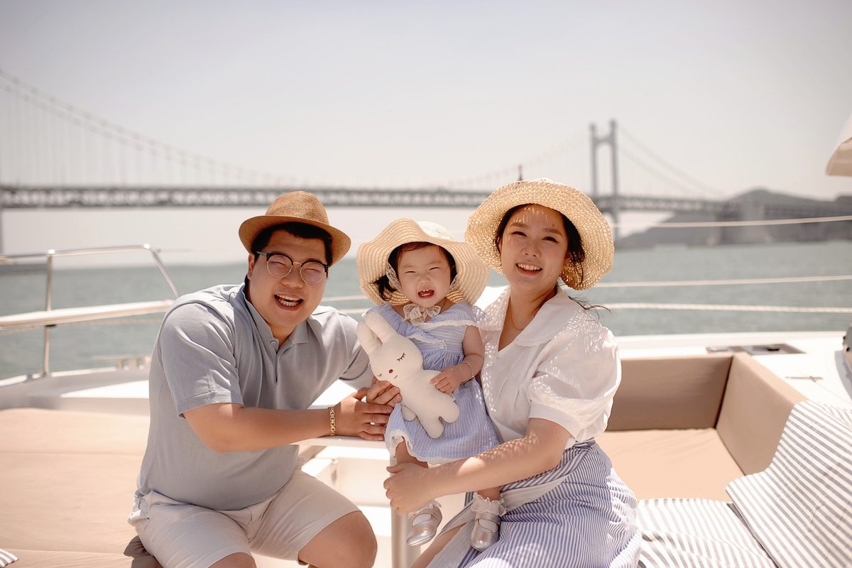 Family on a yacht with Gwangan Bridge behind