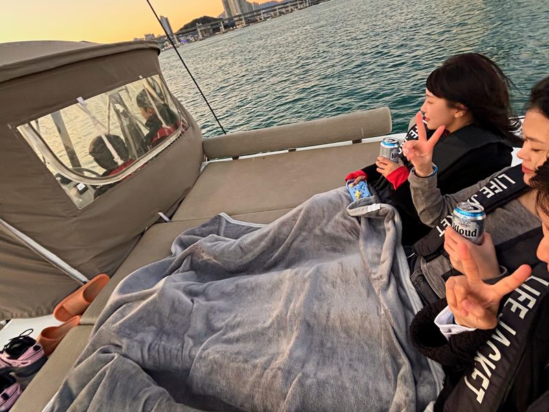 Guests on the yacht sofa under blankets