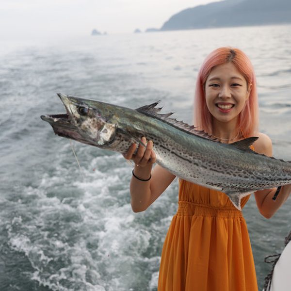 Guest holding a fish caught on the yacht