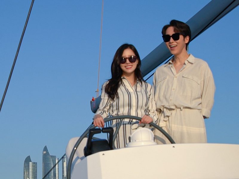 A passenger taking the wheel in the wheelhouse