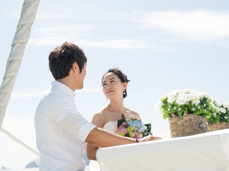 Bride and groom facing each other on the yacht deck